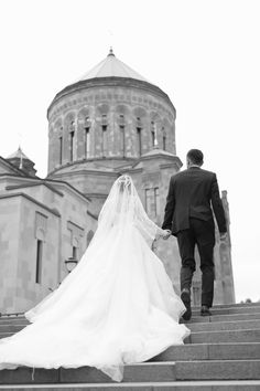 a bride and groom walking up some steps