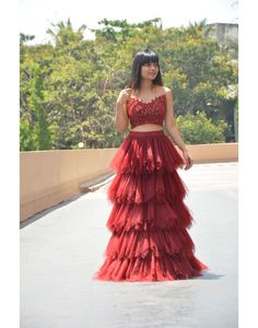 This eye catchy set of wine red skirt top is absolutely perfect for all types of parties and receptions. The skirt has 5 tiers of wine red geathers layered beautifully. Sheer blouse is hand worked with self color (wine red) beads, sequence and Cutdana. Product Details: Type: Skirt topColor: Winish Red.Skirt Fabric: Swiss net with raw silk lining and cancanWork: Self color bead, sequence and Cutdana hand work.Occasion: Festival Wear, Wedding Wear, Party Wear, New Year, Sangeet, Reception Measurem Wine Red Skirt, Types Of Parties, Skirt And Crop Top, Skirt Top Set, Traditional Indian Dress, Red Crop Top, Red Beads, Red Skirt, Dress Rental