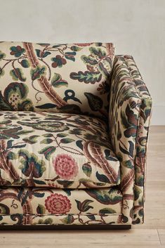 a chair that is on the floor with a flowery pattern in front of it