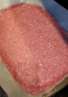 raw ground meat is sitting on top of parchment paper