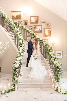 a bride and groom kissing on the stairs at their wedding reception in front of candles