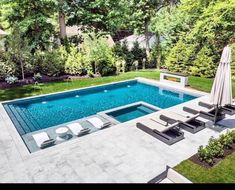 an outdoor swimming pool with lounge chairs and umbrella