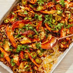 a pan filled with shrimp and vegetables on top of a table