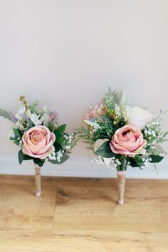 two pink roses and baby's breath flowers in vases