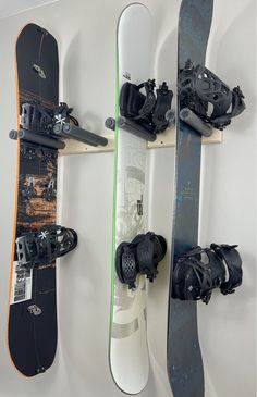 three snowboards mounted to the side of a wall next to each other on wheels