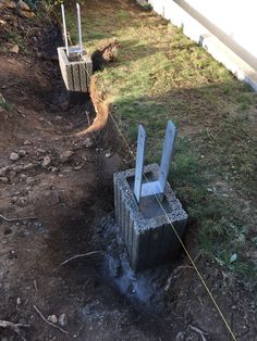 two cement blocks sitting on top of a dirt field