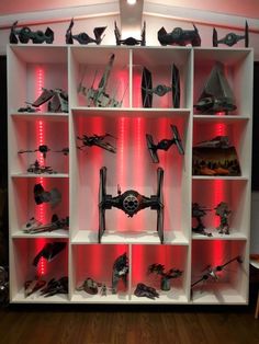 star wars action figures are on display in a bookcase with red light behind them