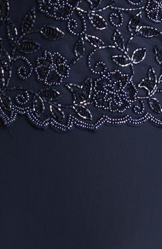 the back of a dress with sequins and beading on it, in dark blue