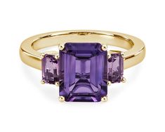 A mesmerizing amethyst sits at the centre of this gorgeous ring, flanked by pink amethysts on either side for a beautiful effect. It is crafted in 14k yellow gold, which promises a warm, timelessly luxurious gleam. Luxury Amethyst Ring Emerald Cut, Luxury Emerald Cut Amethyst Ring, Multi-stone Amethyst Ring In Yellow Gold, Yellow Gold Amethyst Ring With Emerald Cut, Purple Gemstone Baguette Cut Rings, Purple Gemstone Rings With Baguette Cut, Purple Baguette Cut Gemstone Rings, Purple Amethyst Rings With Baguette Cut, Purple Amethyst Baguette Cut Ring