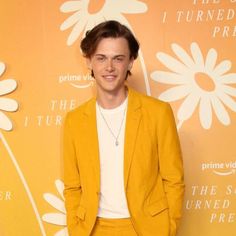 a young man in a yellow suit and white t - shirt