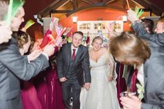 a bride and groom walk through confetti filled with streamers