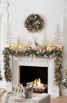 a living room decorated for christmas with white furniture and decorations on the fireplace mantel