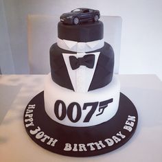 a black and white birthday cake with a car on top that says 007th birthday