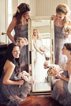 the bridesmaids are getting ready for their wedding in front of a large mirror