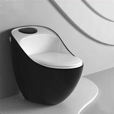 a black and white toilet sitting on top of a white floor next to a wall