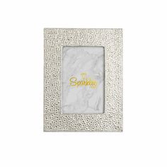 a white marble frame with the word sparkle in gold foil on it, and a small square