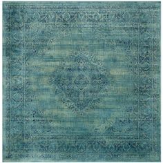 a blue rug with an ornate design on the top and bottom, in shades of green