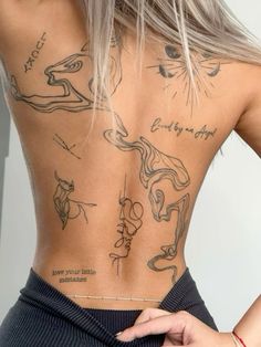 the back of a woman's body with tattoos on her upper and lower back