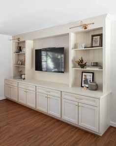 an entertainment center with built in cabinets and a flat screen tv mounted on the wall