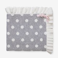 a gray and white polka dot blanket with pink ribbon