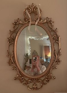 a woman taking a selfie in front of a mirror with a bow on it