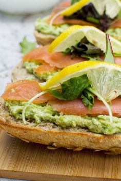 the sandwich is topped with avocado, salmon and lettuce on bread