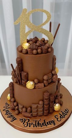 a three tier chocolate birthday cake with gold decorations