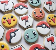 decorated cookies are arranged in the shape of pokemon's heads and numbers on display