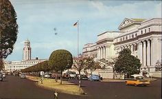 an old photo of a city street with cars and buildings