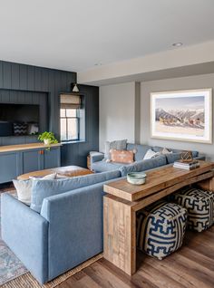 a living room filled with furniture and a wooden table in front of a tv mounted on the wall