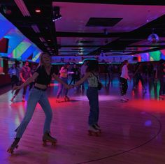 several people are skateboarding in a brightly lit room