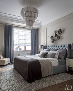 a bedroom with a large bed and chandelier