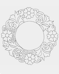 a circular frame with flowers and leaves on it, outlined in black and white ink