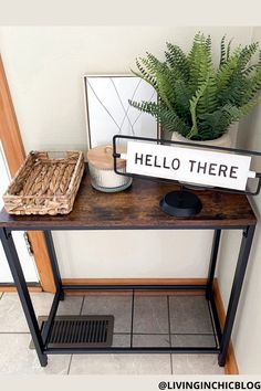 a table with a sign that says hello there on it and a basket next to it