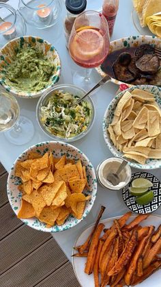 a table filled with plates and bowls of food on top of a white table cloth