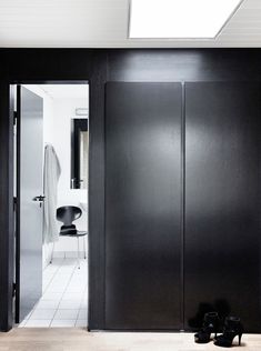 a pair of black shoes sitting on the floor in front of an open door to a bathroom