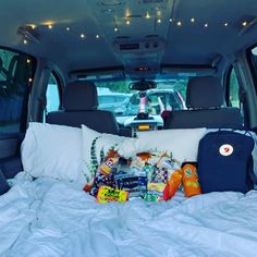 the back end of a van filled with pillows and food