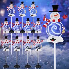 a snowman is standing next to some candy lollipops on a stick