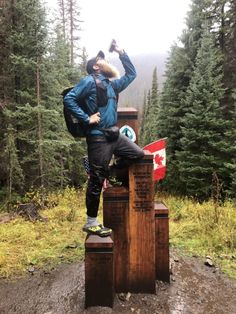 a man standing on top of a wooden post