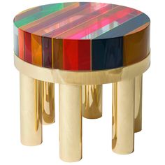 a multicolored table with gold legs and a glass top on the bottom is shown