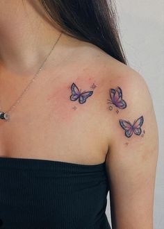 two butterflies on the back of a woman's shoulder and arm, both with small stars