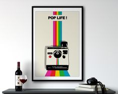 a polaroid camera sitting on top of a table next to a bottle of wine