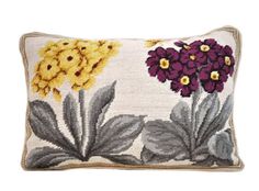 a pillow with flowers on it and leaves around the edges in yellow, purple, and grey colors