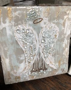 an angel wings painting on a piece of metal