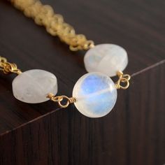 "This is a made-to-order listing with a lead time of approx. 2 weeks. Please contact me prior to purchase if you have any questions about the shipping date. This rainbow moonstone bracelet features lovely moonstone gems in a smooth coin shape. Three stones are linked together with gold filled wire, while strands of gold filled chain complete the body of the bracelet. The stones are approx. 10mm in diameter and have a beautiful blue flash, particularly the middle stone. A petite lobster clasp sec Schmuck Gold, Rainbow Moonstone Jewelry, June Birthstone Jewelry, Rainbow Necklace, Moonstone Bracelet, Labradorite Necklaces, Jewelry Birthday, June Birthstone, Moonstone Jewelry