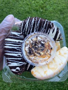 a person in gloves holds up a plate with desserts and fruit on it,