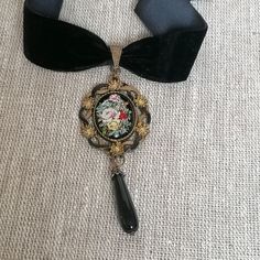 This gorgeous Victorian/Gothic style black velvet choker with a flower cameo placed in an antique gold and back hand painted pendant finished with black agates teardrop by a will definitely draw everyone's attention to whatever the rest of the garment of your choice for the event attended might be.  Detailed, hand crafted and carefully designed.  Measurement Pendant length----3,5 inches (9 cm) choker length----14 inches (37 cm) Closed with adjustable lobster claw, but size can always be changed Victorian Style Adjustable Choker Jewelry, Adjustable Victorian Style Choker Jewelry, Victorian Metal Choker For Gift, Victorian Metal Choker As Gift, Victorian Metal Choker Gift, Handmade Black Victorian Choker, Victorian Black Pendant Jewelry, Victorian Style Black Pendant Jewelry, Elegant Black Pendant Choker