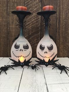 two halloween candlesticks decorated with jack - o'- lantern faces and spider legs