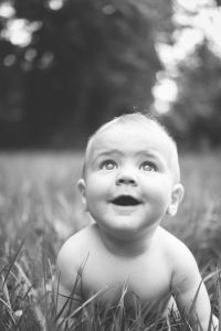 a black and white photo of a baby in the grass