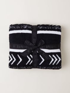 the black and white towel is wrapped in a ribbon with an arrow design on it